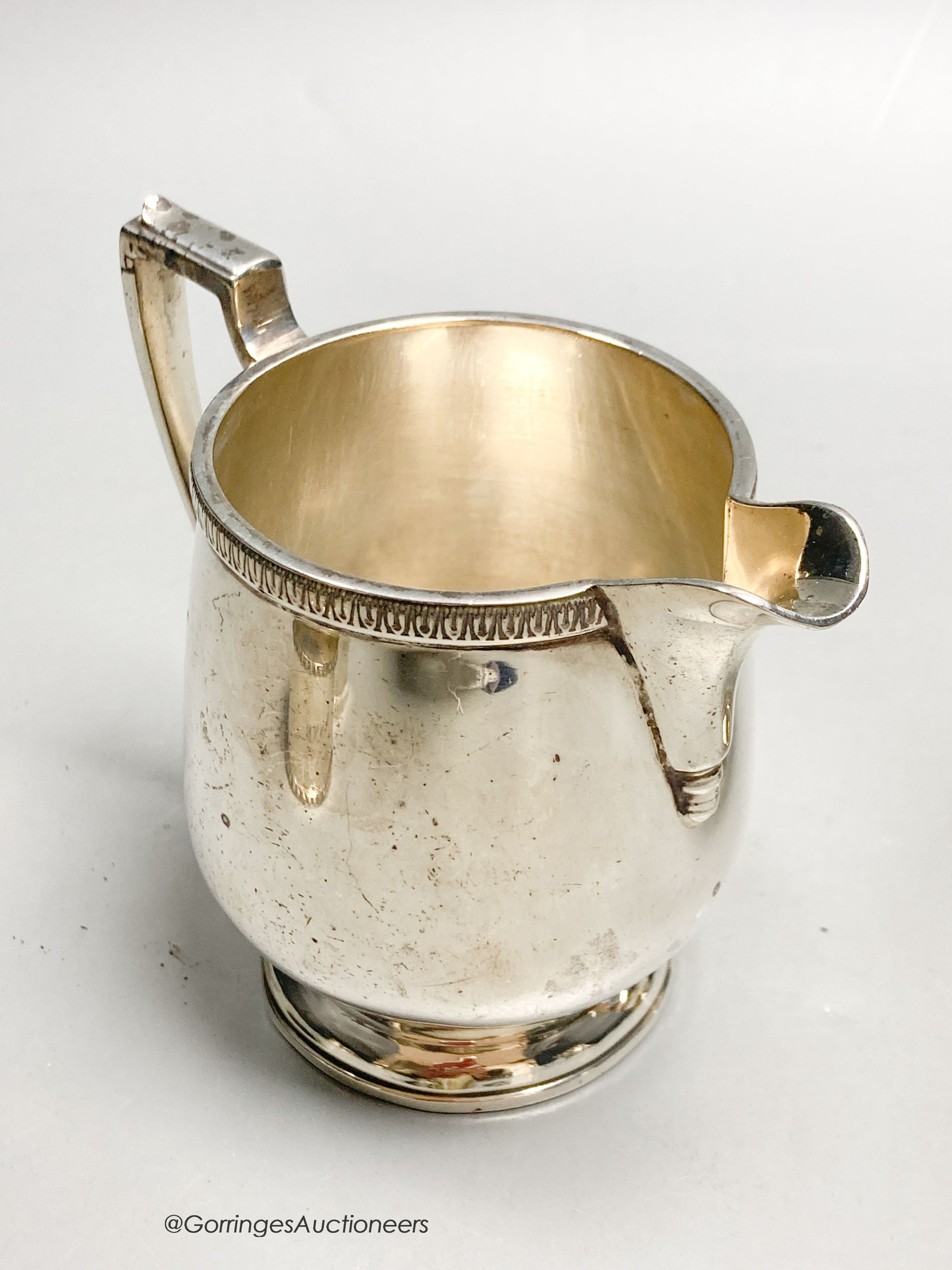 A George V silver jug, Birmingham, 1928, a silver caster and two silver napkin rings, 10oz.